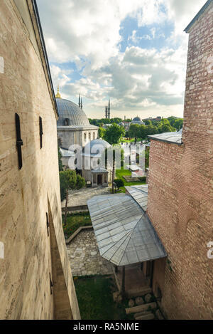 Vue de l'extérieur des bâtiments en forme de dôme entourant le musée Sainte-Sophie, minarets de la Mosquée Bleue peut être vu dans l'arrière-plan, Istanbul, Turquie Banque D'Images