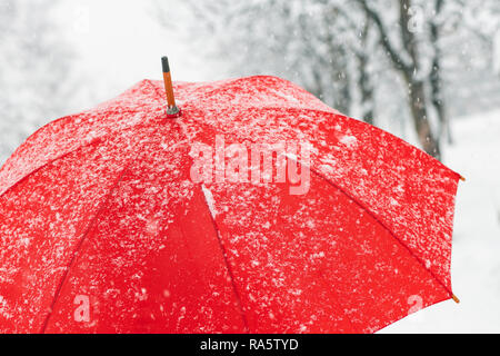 Close up de parapluie rouge dans la neige avec le gel et les flocons Banque D'Images