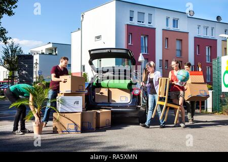 Maison privée propose, les gens le chargement d'une voiture familiale, des amis aident Banque D'Images