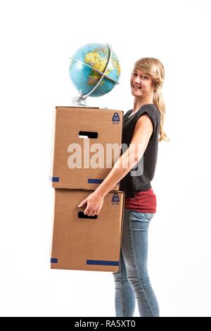 Jeune femme portant des cartons et un globe Banque D'Images