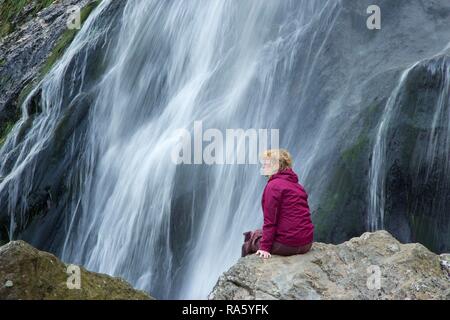 Femme en face de Powerscourt Waterfall, comté de Wicklow, Irlande, Europe Banque D'Images