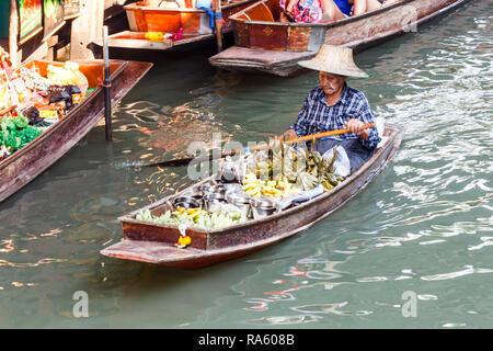 Damnoen Saduak - 4 mars 2014 : une femme vendeur paddles son bateau le long du canal. La ville est célèbre pour son marché flottant. Banque D'Images