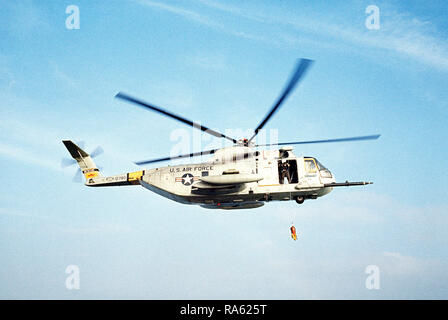1977 - Une mer-air vue côté droit d'un HH-3 Jolly Green Giant de la descente d'une ligne de sauvetage par hélicoptère au cours d'une mission de sauvetage pratique sur la côte californienne. L'hélicoptère est affecté à la 129e groupe de sauvetage et de récupération de l'aérospatiale de l'Air National Guard. Banque D'Images