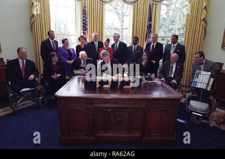 Photographie du Président William Jefferson Clinton signe l'ordre exécutif 13078, l'accroissement de l'emploi des adultes handicapés, dans le bureau ovale Banque D'Images