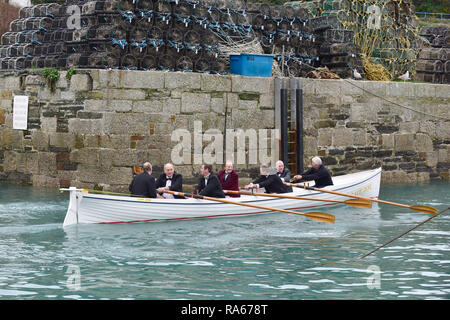 Newquay, Cornwall, UK. 21 avril, 2018. Les principaux membres de Newquay Rowing Club de porter des smokings sur leur rapport annuel Port dâ€™Runâ€™. Une bouteille de porto est ramé à travers la baie de Newquay à île de Porth par ces rameurs dans un pilote traditionnel cornouaillais Gig. Une fois qu'ils la bouteille est consommée par les rameurs qui puis revenir au port de Newquay. Gordon 1928/Alamy Live News. Banque D'Images