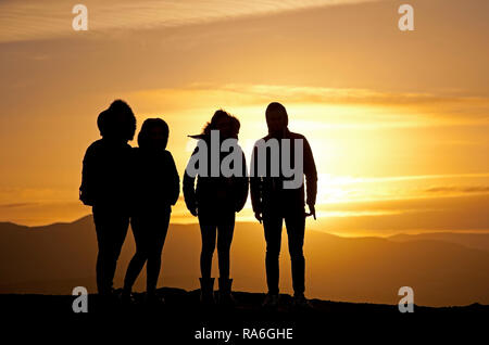 Edinburgh, Ecosse, Royaume-Uni. 2 janvier 2019. Météo France, les touristes en silhouette profiter de la vue depuis le siège d'Arthur sommet à Holyrood Park juste autour du coucher du soleil, bien que la température est de moins 1 degré après une nuit de moins six degrés. Banque D'Images