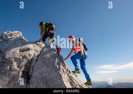 Guide de montagne de guider une jeune femme sur une courte corde à travers un rocher, Wiederroute, Watzmann, Schönau am Königssee Banque D'Images
