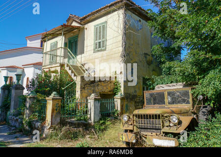 Vieux bâtiment délabré à Alexandroúpoli, unité régionale de l'Evros en Macédoine orientale et Thrace. Vieux camion militaire sur la droite Banque D'Images