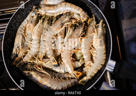 Les langoustines dans une poêle sur une plaque de cuisson prêt à cuire. Banque D'Images