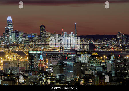 D'Oakland et de San Francisco à l'horizon de crépuscule illuminé par les lumières des Fêtes. Banque D'Images