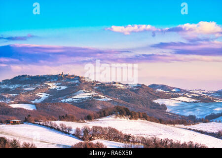 La neige en Toscane, panorama hivernal au coucher du soleil. Village de Radicondoli, oliviers et vignobles, Sienne, Italie l'Europe. Banque D'Images