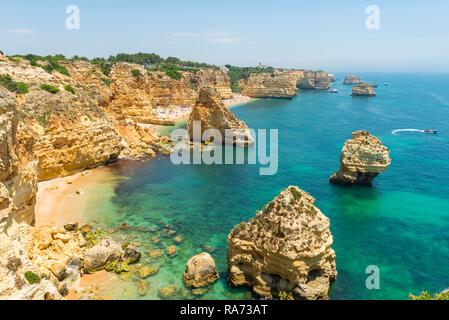 La mer turquoise, Praia da Marinha, robuste côte rocheuse de grès, formations rocheuses dans la mer, Algarve, Lagos, Portugal Banque D'Images