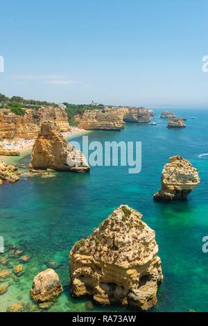 La mer turquoise, Praia da Marinha, robuste côte rocheuse de grès, formations rocheuses dans la mer, Algarve, Lagos, Portugal Banque D'Images