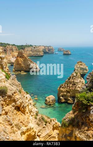 La mer turquoise, Praia da Marinha, robuste côte rocheuse de grès, formations rocheuses dans la mer, Algarve, Lagos, Portugal Banque D'Images