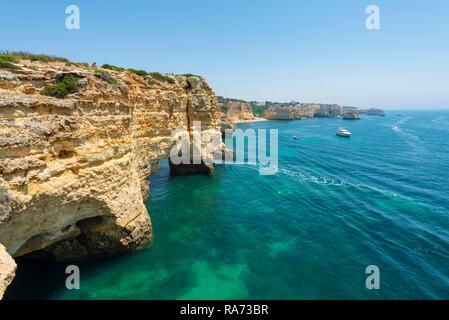 La mer turquoise, Praia da Marinha, robuste côte rocheuse de grès, formations rocheuses dans la mer, Algarve, Lagos, Portugal Banque D'Images