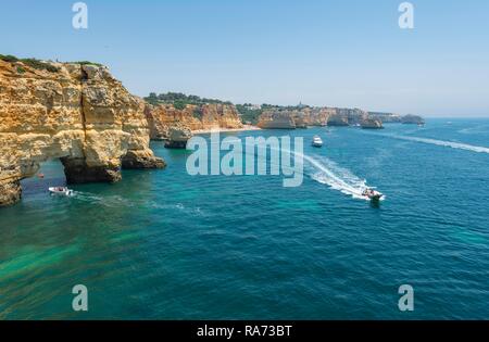 Bateaux de touristes, la mer turquoise, Praia da Marinha, robuste côte rocheuse de grès, formations rocheuses dans la mer, Algarve, Lagos Banque D'Images