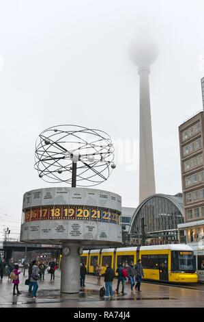 L'horloge mondiale, train tramway jaune, tour de la télévision dans le brouillard, Alex, Alexanderplatz, Berlin Mitte, Berlin, Allemagne Banque D'Images