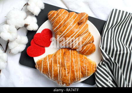 Petit-déjeuner romantique au lit, les croissants sur drap de lit blanc, Vue du dessus Banque D'Images