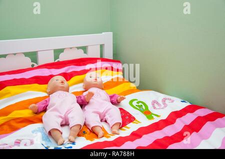 Deux poupées sur un lit d'enfant Banque D'Images