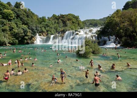 La natation de personnes en face d'une cascade, Parc National de Krka, Dalmatie, Croatie Banque D'Images