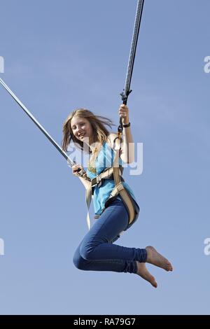 Fille sur trampoline bungee Banque D'Images