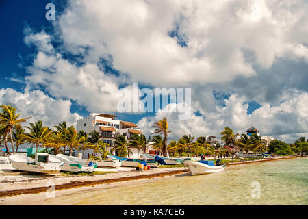 Costa Maya, Mexique - Février 01, 2016 : mer plage avec des bateaux sur le sable blanc, palmiers, station touristique verte sur journée ensoleillée sur nuageux ciel bleu. Des vacances d'été, voyager concept Banque D'Images