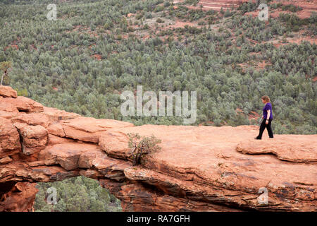 Femme marchant sur rocher naturel appelé arch bridge Devils à Sedona Arizona USA Banque D'Images