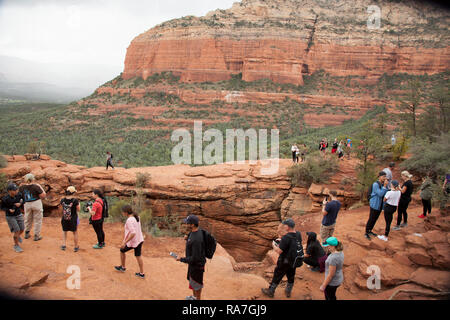 Les gens attendent en ligne à traverser un pont Devils natural rock arch formation en Arizona Sedona Banque D'Images