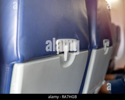 Bac alimentaire plastique fermer jusqu'à l'arrière de sièges en cuir bleu sur faible coût avion commercial. Banque D'Images