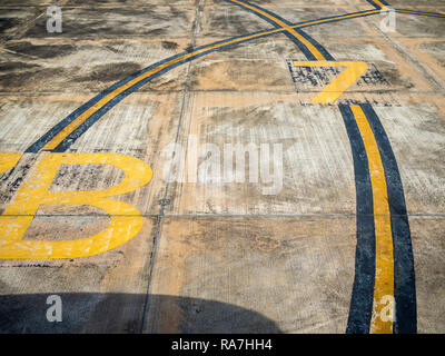 Jaune et Noir bandes incurvées et numéro de code sur la piste en béton à l'aérodrome. Banque D'Images