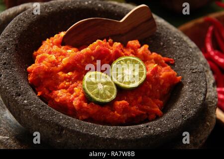 Le Terasi Sambal oelek. Condiment traditionnel indonésien de piment rouge et la pâte de crevettes fermentées. Servi sur un mortier en grès. Banque D'Images