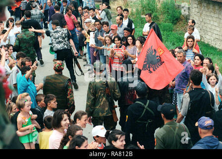 Les membres de la section locale de l'Armée de libération du Kosovo, l'UCK, marche dans les rues de Koretin, du Kosovo à l'honneur des Marines (la 26e Marine Expeditionary Unit (MEU). Banque D'Images