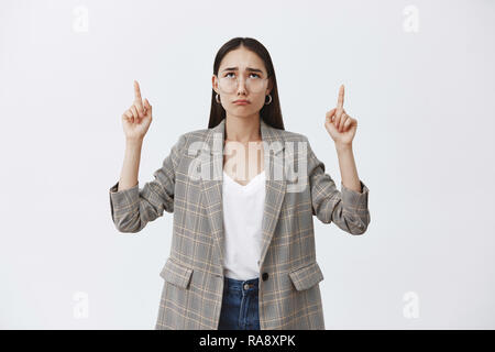 Oh non, encore de la pluie. Portrait de jolie femme en colère misérable aux cheveux noirs et portant des lunettes veste élégante, bouder et pleurnicher tout en relevant et regardant vers le haut, d'être sombre et irrité Banque D'Images