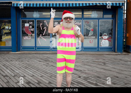 Portrait de posé un homme âgé dans un chapeau de Père Noël et Noël onesie lors de l'Assemblée Polar Bear Club le jour de l'an nager dans Coney Island, Brooklyn, New York. Banque D'Images