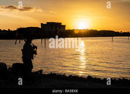 Un joueur de cornemuse jouant, silhouette sur le coucher du soleil Banque D'Images
