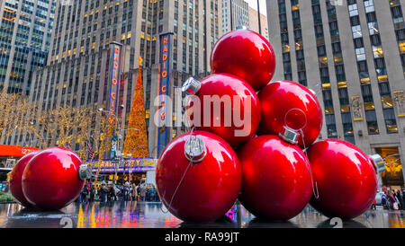 Les boules de Noël rouge géant près de Radio City Music Hall sur la 6ème Avenue, New York City. Banque D'Images
