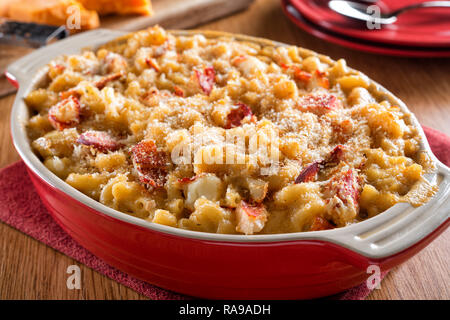 Un délicieux petit fromage et mac homard en cocotte sur une table en bois. Banque D'Images