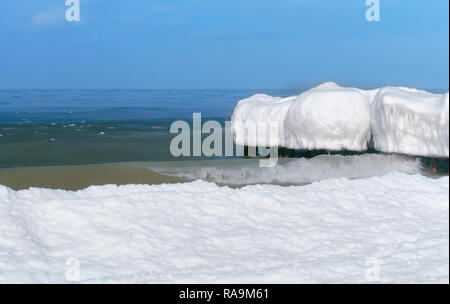 La glace sur le brise-lames, sur la côte de la mer couverte de neige Banque D'Images