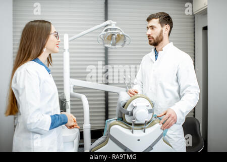 Dentiste talking with woman assistant pendant la pause dans le cabinet dentaire Banque D'Images