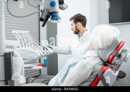 Beau dentiste au cours de la consultation avec les hauts femme dans le cabinet dentaire Banque D'Images
