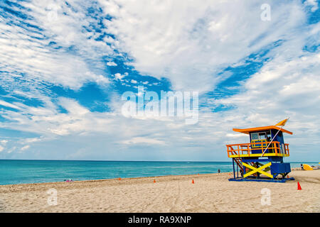 South Beach, Miami, Floride, lifeguard chambre dans un décor de style Art déco sur nuageux ciel bleu et l'océan Atlantique en arrière-plan, célèbre lieu de voyage Banque D'Images