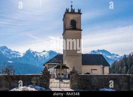 Alpes italiennes comme arrière-plan pour la montagne l'église avec clocher et cross sur elle à Castello, petite ville de Trento, Trentino, en Italie. Banque D'Images