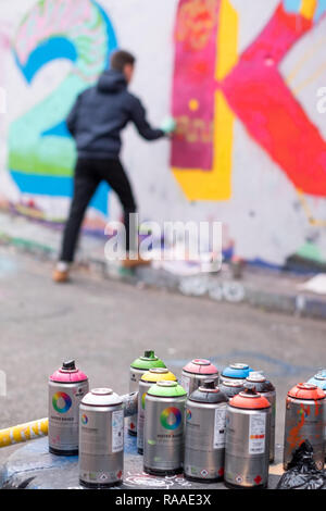 Les jeunes artistes de graffiti au travail, Leake Street tunnel. Waterloo, London UK. Pots de peinture en premier plan. Banque D'Images