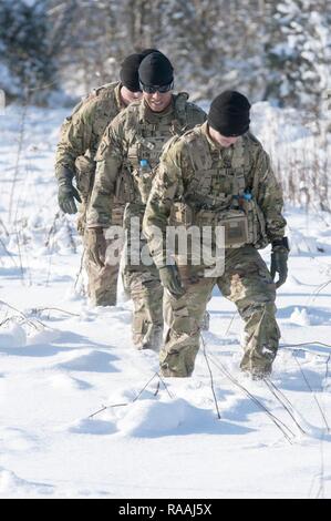 Le Sgt. Nick Keepers-Phillips de Mustang, Oklahoma dirige une équipe de soldats de la Compagnie A, 1er Bataillon, 179ème régiment d'infanterie, 45e Brigade d'infanterie de l'équipe de combat dans la neige lors de la validation de l'emplacement des points de navigation au maintien de la paix et la sécurité internationale Centre près de l'Ukraine, l'viv le 16 janvier. L'équipe d'Keepers-Phillips a été l'une des trois équipes d'une entreprise qui a traversé jusqu'à la taille de la neige profonde à la recherche de points avant d'unités de l'armée ukrainienne arrivent à l'IPSC pour la formation. Banque D'Images