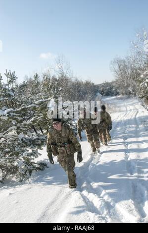 Le Sgt. Nick Keepers-Phillips de Mustang, Oklahoma dirige une équipe de soldats de la Compagnie A, 1er Bataillon, 179ème régiment d'infanterie, 45e Brigade d'infanterie de l'équipe de combat dans la neige lors de la validation de l'emplacement des points de navigation au maintien de la paix et la sécurité internationale Centre près de l'Ukraine, l'viv le 16 janvier. L'équipe d'Keepers-Phillips a été l'une des trois équipes d'une entreprise qui a traversé jusqu'à la taille de la neige profonde à la recherche de points avant d'unités de l'armée ukrainienne arrivent à l'IPSC pour la formation. Banque D'Images