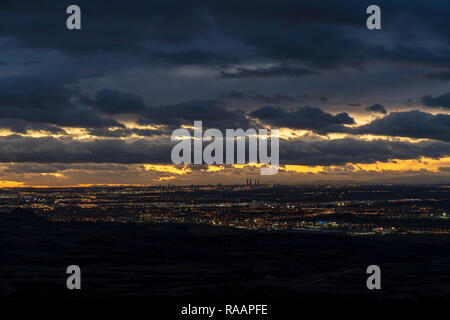 Vue de nuit sur la ville de Madrid et Alcala de Henares au coucher du soleil, ciel nuageux, éclairage, feux de nuits, des gratte-ciel. Madrid, Espagne. Banque D'Images