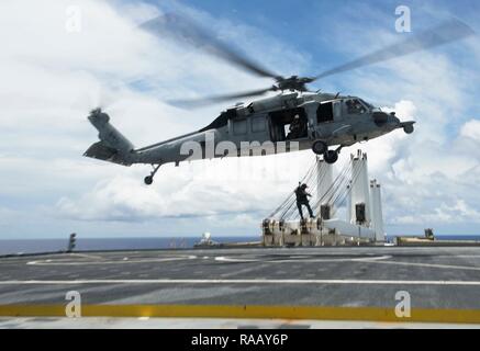 Océan Pacifique (23 août 2018) - Naval Air Crewman (hélicoptère) 2e classe Jacob Ward, chef de l'équipe de nageurs-sauveteurs et affecté à l'Escadron d'hélicoptères de combat de la mer 25 (HSC-25), 2ème classe Corpsman Hôpital abaisse Kyle Bowen, un technicien médical de recherche et sauvetage attribuée à HSC-25, sur le pont de vol de véhicule de catégorie de Watson-cargo USNS Dahl (T-AKR-312) à HSC-25 MH-60S Seahawk hélicoptère pendant un exercice d'évacuation médicale, le 23 août. 25 HSC est la seule marine MH-60S déployées à l'avant de l'escadron expéditionnaire. Dans le cadre d'hélicoptère de combat Pacifique Mer aile, il fournit un heli Banque D'Images