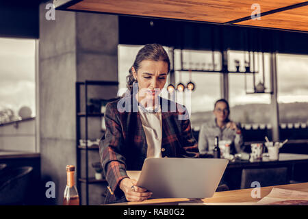 Jeune femme émotionnelle à regarder l'écran de son ordinateur Banque D'Images