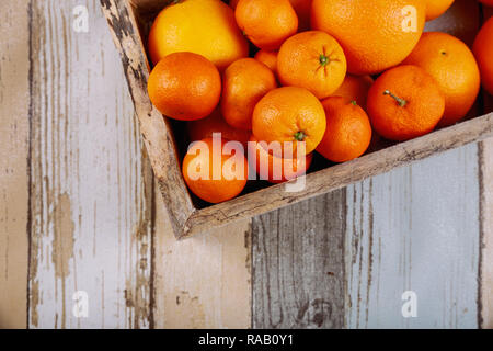 Tangerines fraîches dans de vieux fort avec sur fond de bois. Banque D'Images