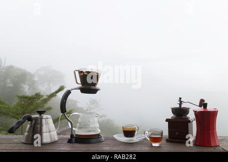 Tasse de café du matin avec le Rotary rectifieuse de café sur la table en bois avec fond de montagne au lever du soleil et de la mer de brouillard, de droit avec l'exemplaire de l'espace. Banque D'Images